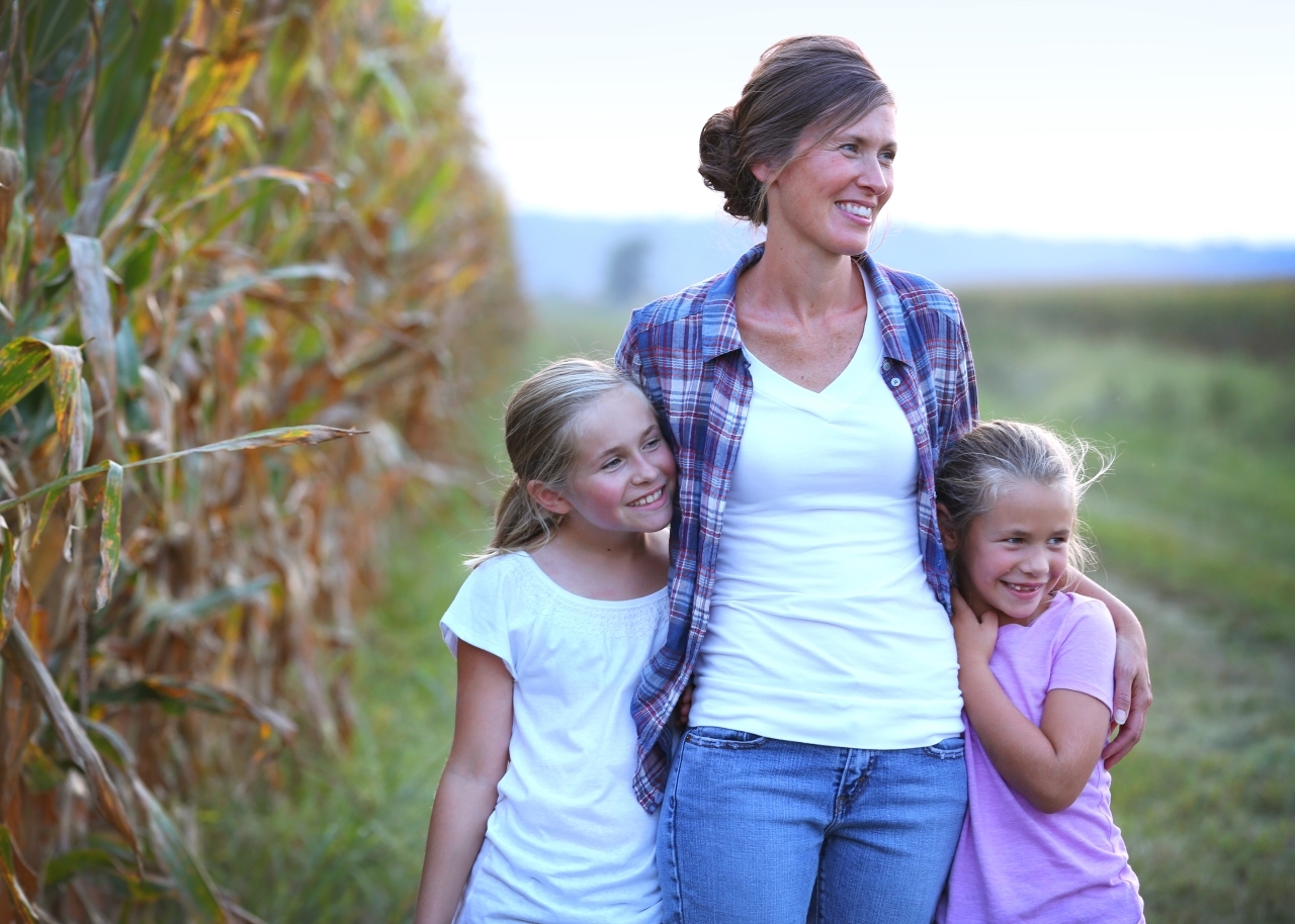 Woman and her daughters next to corn field